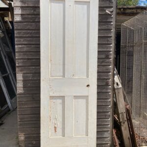 Front view of a painted Victorian four panel door in need of restoration.