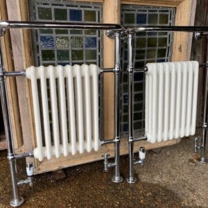 Two matching heated towel rails with integrated traditional style radiators.