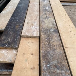 A selection of reclaimed pine floorboards laid flat to display the natural wood grain and rich period patina.